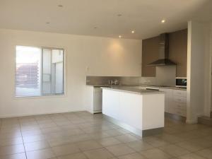 a large kitchen with a white counter and a window at Azure in Bridport +8 photos