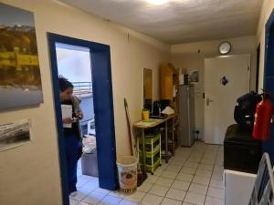 a person standing in a room with a kitchen at einfacher Schlafplatz ohne Ansprüche in Essen