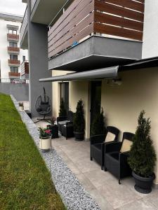 a patio with couches and potted plants on a house at Apartament Ariana Rasnov in Râşnov