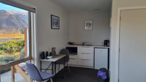 a kitchen with a table and chairs and a window at Lodges On Pearson Unit 1 in Cromwell