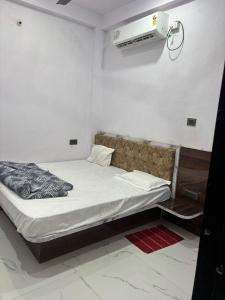 a small bedroom with a bed and a air conditioner at Dixit's Residency in Godarpura