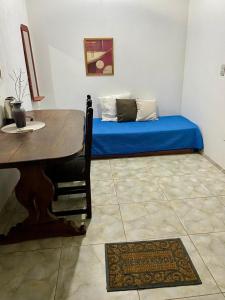 a room with a table and a bed with blue sheets at Depto Ibarreta in Ibarreta