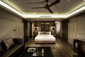 a hotel room with a bed and a couch at De Chai the Deco Chiang Mai - SHA Plus in Chiang Mai