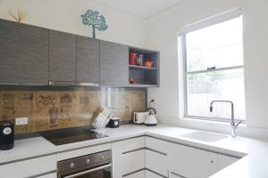 a kitchen with white cabinets and a sink and a window at Historic Getaway in Launceston