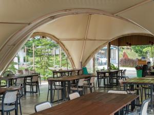 an empty restaurant with wooden tables and chairs at Lù Yīng Retreats in Bukit Tinggi