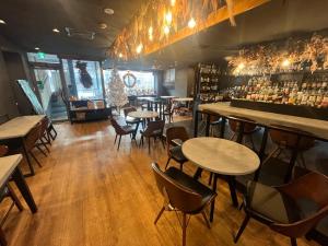 a restaurant with tables and chairs and a bar at Business Inn Norte 2 in Sapporo