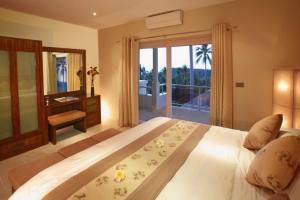 a bedroom with a large bed with a large window at Kalara Gardens in Ban Bang Po