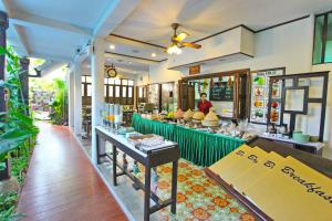 a restaurant with a counter in the middle of a room at Shewe Wana Boutique Hotel in Chiang Mai