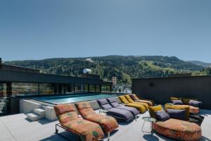 a patio with lounge chairs and a swimming pool at nōa Schladming in Schladming