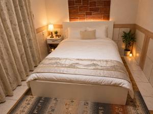 a bedroom with a large white bed and a window at Villa Amoria in Miyazaki
