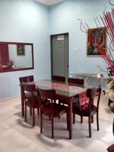 a dining room table and chairs in a room at Homestay Seri Nipah Perlis in Kangar