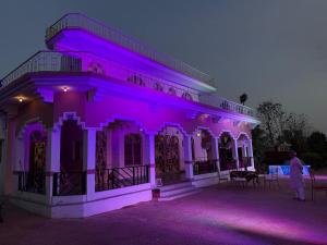 a building with purple lights on it at night at Sariska Haveli in Alwar