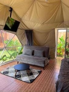 a living room with a couch in a tent at Dome Gloria in Panjadakan