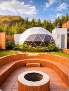 a garden with a fountain and a large tent at Dome Gloria in Panjadakan