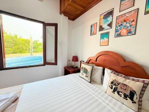 a bedroom with a large bed and a window at Elephant Hotel Luang Parabang in Luang Prabang