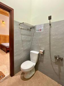 a bathroom with a toilet and a shower at Nhà Nghỉ Thi Anh in Ấp Bia