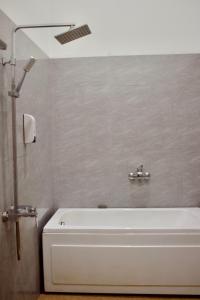 a white bath tub in a bathroom with a shower at Nhà Nghỉ Thi Anh in Ấp Bia