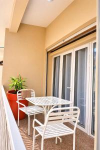 a table and chairs on a balcony with a table and chairs at Milestone Terrace - Premium Apartment near Airport & Super U in Antananarivo