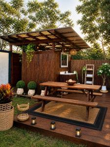 a picnic table in a backyard with a pergola at Pipeline Tropical Bungalow in Haleiwa