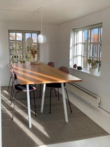 a dining room with a wooden table and chairs at Functionalist House Only 100 Steps To The Beach in Haderslev