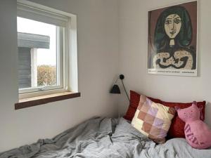 a bedroom with a bed and a picture of a woman at Functionalist House Only 100 Steps To The Beach in Haderslev