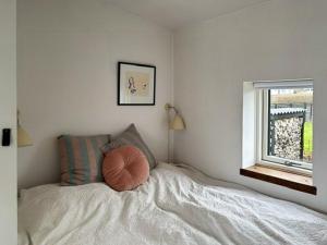 a bedroom with a bed with a pillow on it at Functionalist House Only 100 Steps To The Beach in Haderslev +3 photos