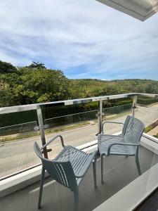 two chairs on a balcony with a view of a road at Ocean Garden Villas Cluster B 3rd Floor Unit C in Boracay