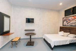 a bedroom with a bed and a table and a tv at Casa Shalom Green in Bacalar