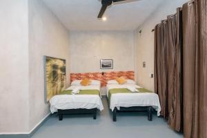 a bedroom with two beds and a brick wall at Casa Shalom Green in Bacalar