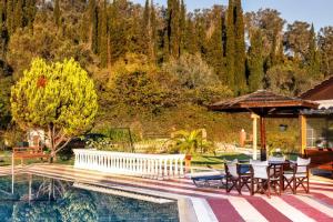 a house with a swimming pool and a table and chairs at Haroula Apartments in Sidari