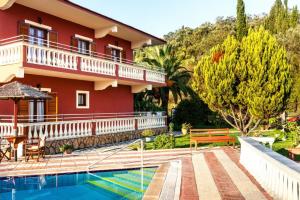 a house with a swimming pool in front of it at Haroula Apartments in Sidari