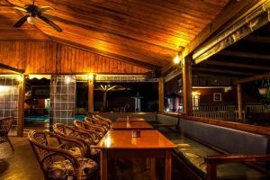 a restaurant with wooden ceilings and tables and chairs at Haroula Apartments in Sidari