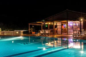 a swimming pool at night with a house at Haroula Apartments in Sidari