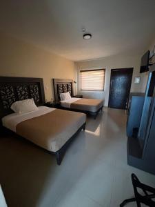 a hotel room with two beds and a window at Hotel Vistas Juventud in Chihuahua