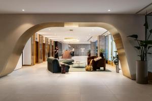 a lobby with an archway with chairs and a living room at Tyrian Albert Park Lake in Melbourne +33 photos