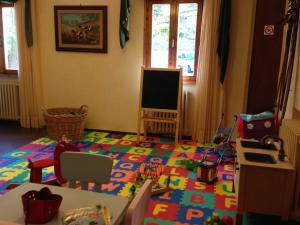 Cette chambre pour enfants dispose d'un sol en jouets et d'une télévision. dans l'établissement Hotel Nuovo Parco, à Sestola