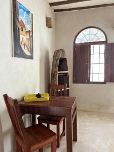 a dining room with a wooden table and chairs at Bahari Studio by Bora Pamoja Homes Pool, Solar Backup & 5 Min to Beach in Jambiani +30 photos