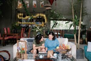 two women sitting on a couch in a living room at Neverland de Papillons in Sa Ðéc +46 photos