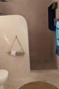 a bathroom with a toilet and a towel at Bahari Studio by Bora Pamoja Homes Pool, Solar Backup & 5 Min to Beach in Jambiani