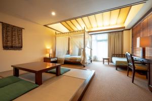 a hotel room with a bed and a living room at Wellness Forest Nasu in Nasu