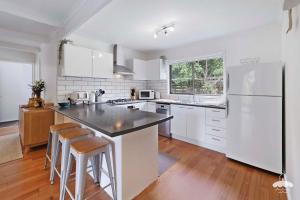 a kitchen with white appliances and a white refrigerator at Between Waters Stay 3 Pay 2 Winter Special in Yanakie +5 photos