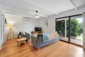 a living room with a couch and a tv at Between Waters Stay 3 Pay 2 Winter Special in Yanakie