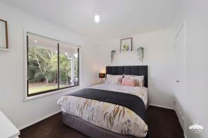 a bedroom with a large bed and a window at Between Waters Stay 3 Pay 2 Winter Special in Yanakie