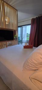 a large white bed in a room with a television at Fare Iki in Papeete