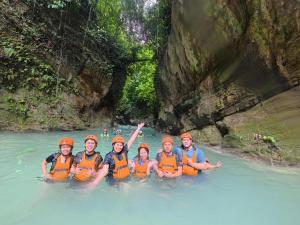a group of people in orange life jackets in a river at CocoVille Guesthouse KUBO in Alegria