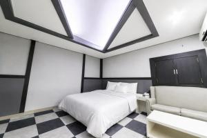 a bedroom with a large bed and a skylight at Hive Hotel in Tongduch'ŏn