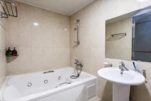 a bathroom with a tub and a sink and a bath tub at Hive Hotel in Tongduch'ŏn