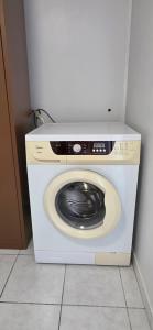 a washer and dryer in a corner of a room at Fare Iki in Papeete