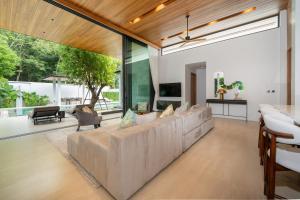 a living room with a large couch and a tv at Botanica Foresta 4BDR by Villacarte in Ban Phru Champa