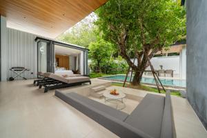 an outdoor patio with a bed and a pool at Botanica Foresta 4BDR by Villacarte in Ban Phru Champa